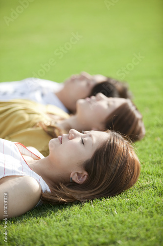 Young people lying down on grass photo