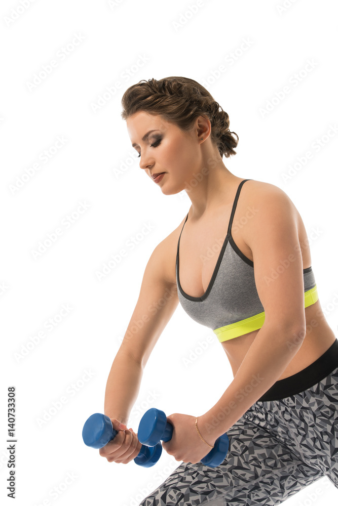 Pretty slim brunette posing with dumbell in studio Pretty slim brunette posing with dumbell in studio