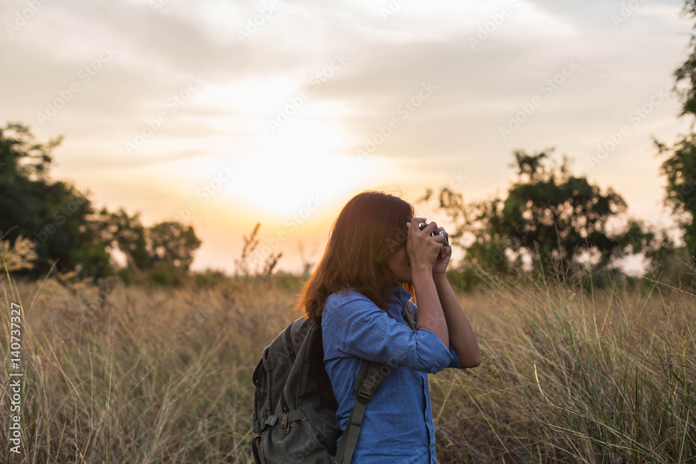 Woman carrying bag of travelers in the field sunsets