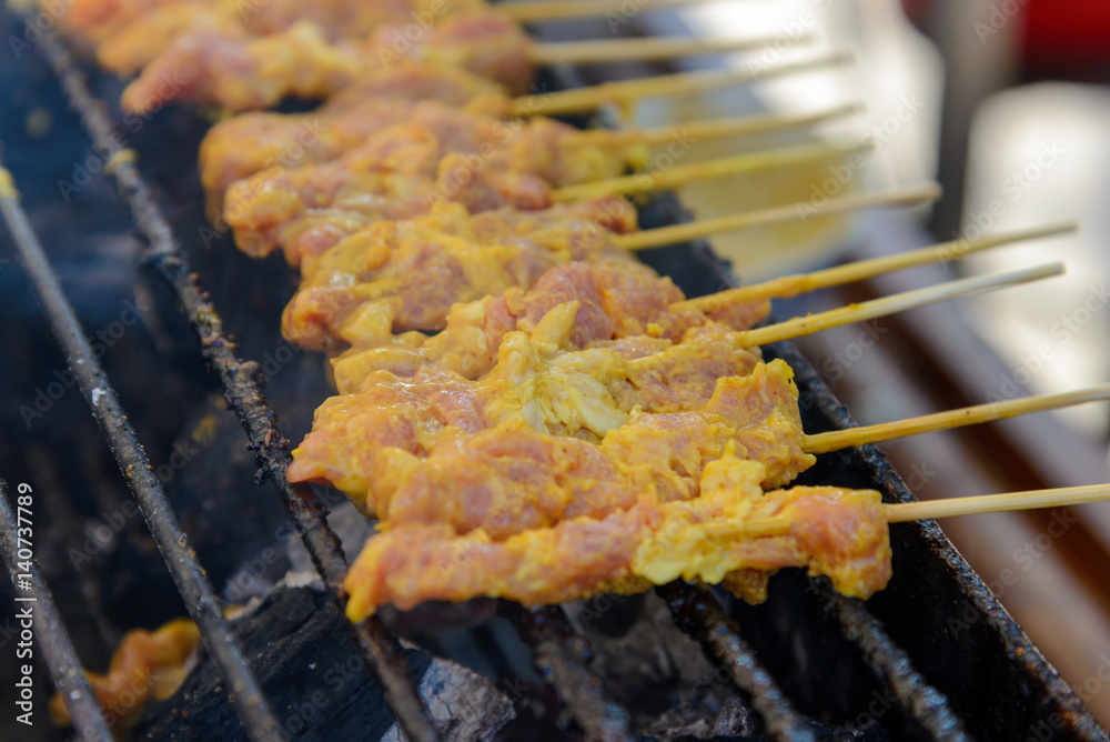 Grilling Pork satay on charcoal stove, Street food. Bangkok. Thailand Grilling Pork satay on charcoal stove, Street food. Bangkok. Thailand
