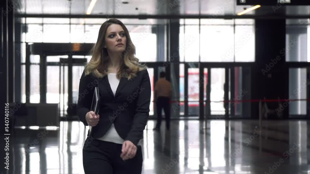 Attractive business woman walking on office building Attractive business woman walking on office building