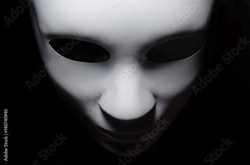 Obraz na płótnie White mask with neutral expression and shadows on dark background w salonie