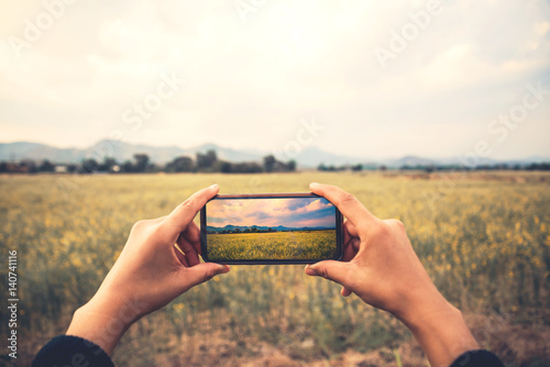 Woman hand using mobile phone photo. Mountain nature