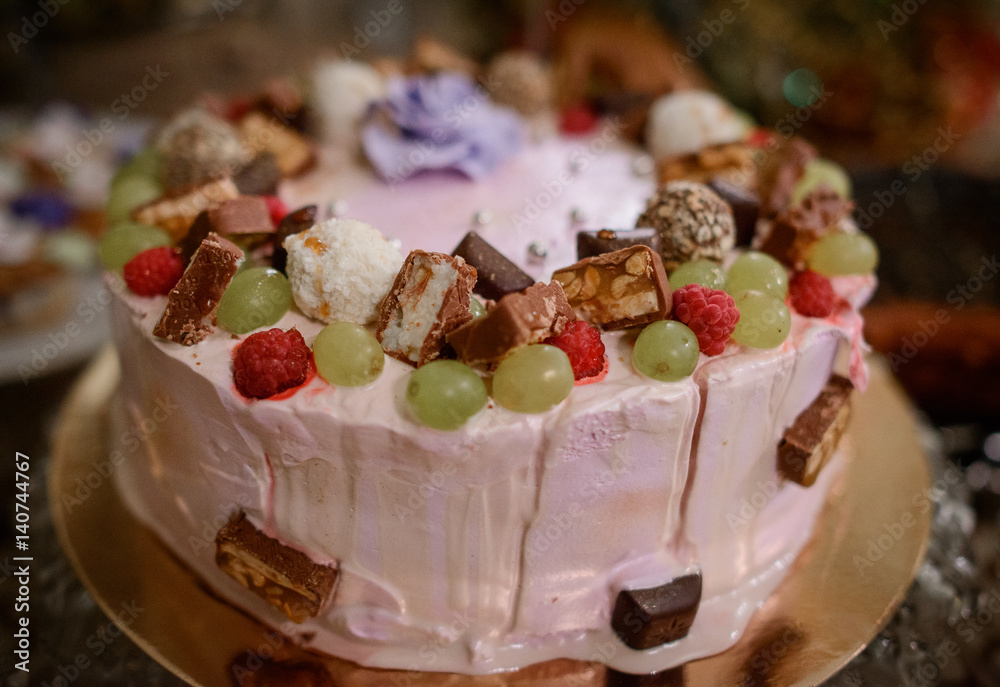 Delicious cake decorated with chocolates and berries