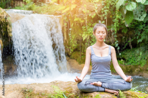 Woman Yoga - relax in waterfall nature