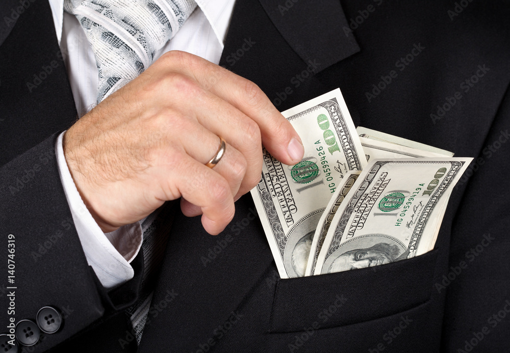 Business man putting dollas into his pocket Business man putting dollas into his pocket
