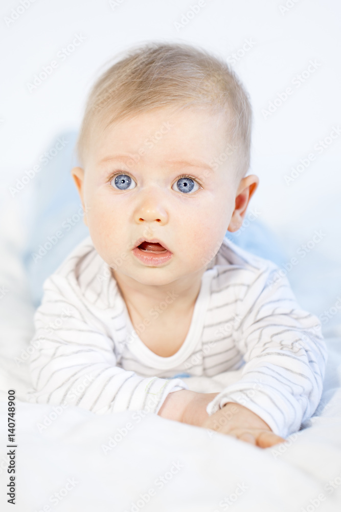 beautiful baby boy lying in bed on white background beautiful baby boy lying in bed on white background