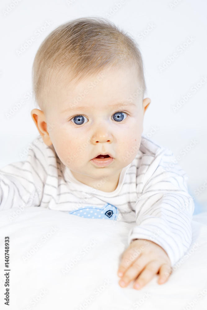 beautiful baby boy lying in bed on white background beautiful baby boy lying in bed on white background