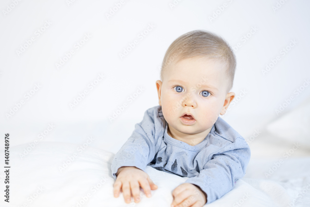 beautiful baby boy lying in bed on white background beautiful baby boy lying in bed on white background