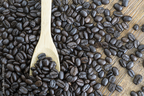 close up of coffee beans in wooden spoon