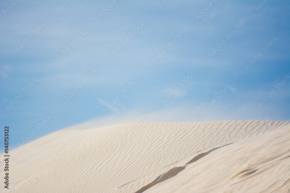 White beach Sand dunes with windy and blue sky background. Western Australia