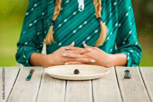 Young lonely woman is having meager meal in times of scarcity. 