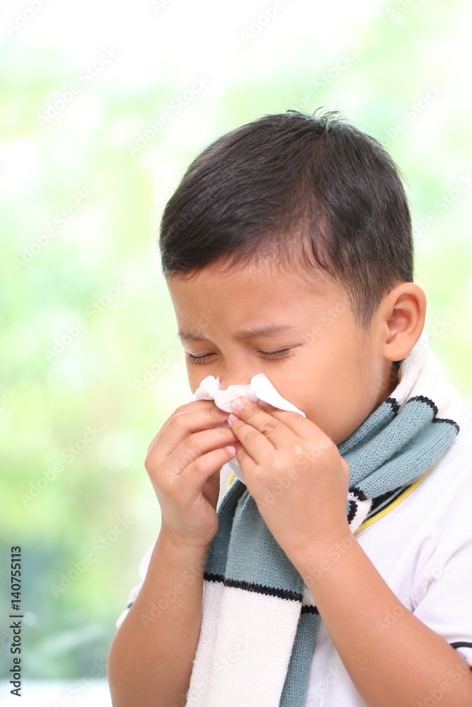Little boy blowing his nose into tissue. healthcare and medical concept. Little boy blowing his nose into tissue. healthcare and medical concept.