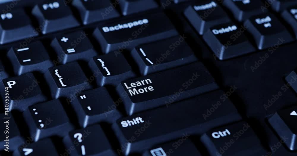 Male finger pressing a Learn More button on the computer keyboard