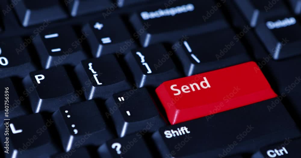Human finger pressing a Send button with red color on the computer keyboard Human finger pressing a Send button with red color on the computer keyboard