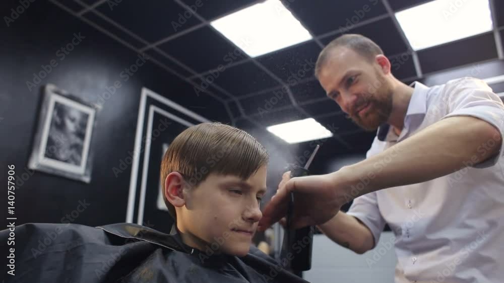 Hairdresser splash water on head of boy in professional hairdressing salon. Hairdresser splash water on head of boy in professional hairdressing salon.
