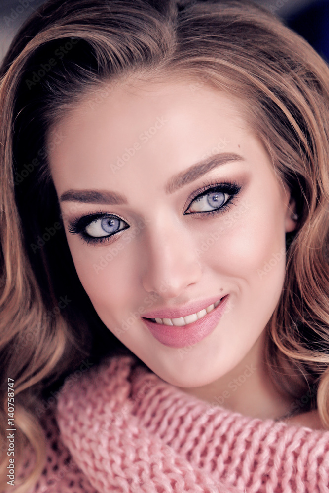 Naklejka premium beautiful young girl with blond curly hair and glowing skin