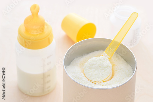 Milchpulver Babynahrung mit Messlöffel und fertigen Milch in Flasche mit Sauger 