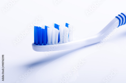 Toothbrush isolated on a white background with reflection. Blue plastic toothbrush. Concept of dental medicine.