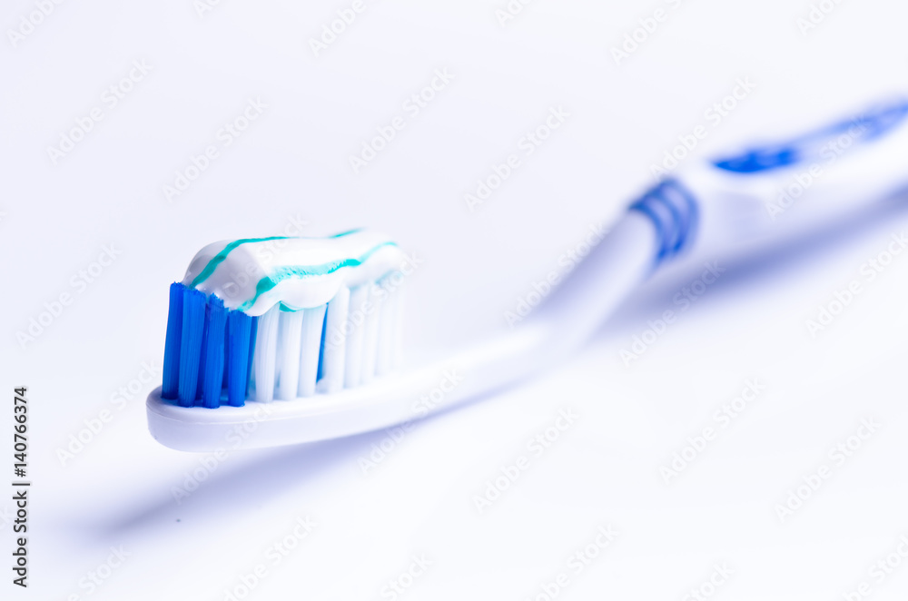 Toothbrush isolated on a white background with reflection and toothpaste. Blue plastic toothbrush. Concept of dental medicine. Toothbrush isolated on a white background with reflection and toothpaste. Blue plastic toothbrush. Concept of dental medicine.