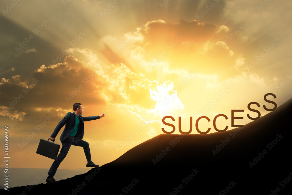 Silhouette of successful businessman with briefcase walking to top of  mountain with powerful of sunlight sky background. Young worker reaching  goal, success and achievement in his life. Copy space. Stock Photo |