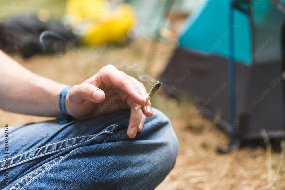 Person Holding Rolled Joint in Camping Area