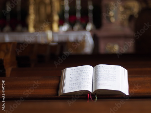 Aufgeschlagenes Gesangsbuch lädt in der Kirche zum Singen ein  photo