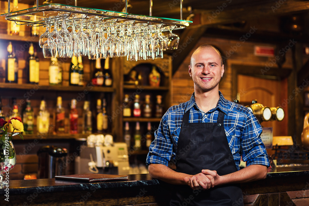Barman at work in pub,Portrait of cheerful barman worker standing