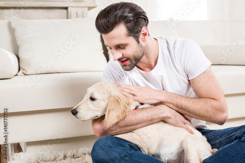 Man petting puppy photo