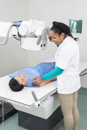 Radiologist Taking X-ray Of Mature Woman Lying On Gurney