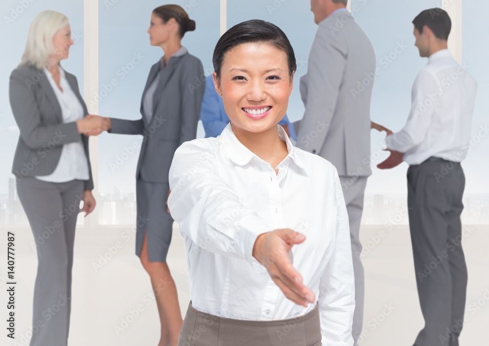 Handshake in front of business people at window Handshake in front of business people at window