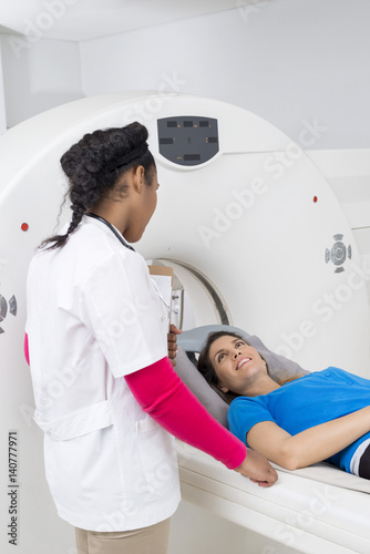 Woman Looking At Female Doctor While Undergoing MRI Scan