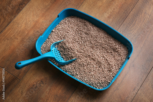 Fototapeta Naklejka Na Ścianę i Meble -  Cat litter box with scoop on wooden floor