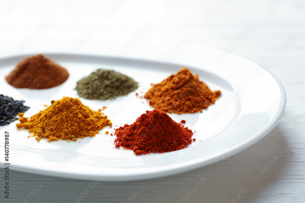 Plate with mix of different spices on wooden table Plate with mix of different spices on wooden table