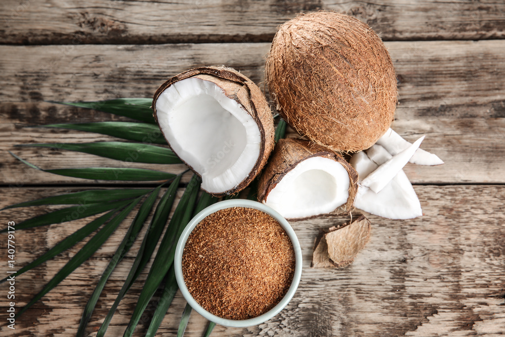 Bowl of brown sugar and coconut on wooden background - obrazy, fototapety, plakaty 