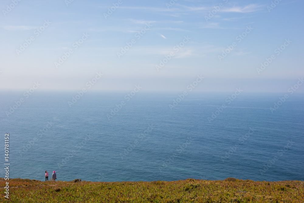 two people on the shore of vast ocean two people on the shore of vast ocean