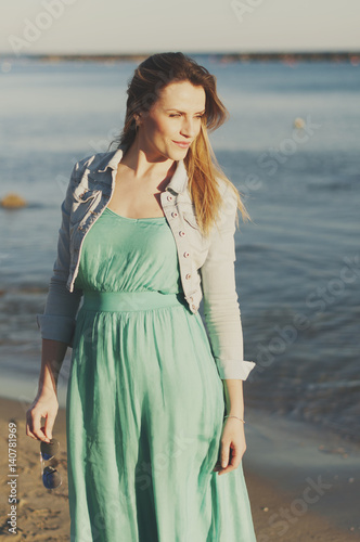 Amazing young woman in green dress near the sea