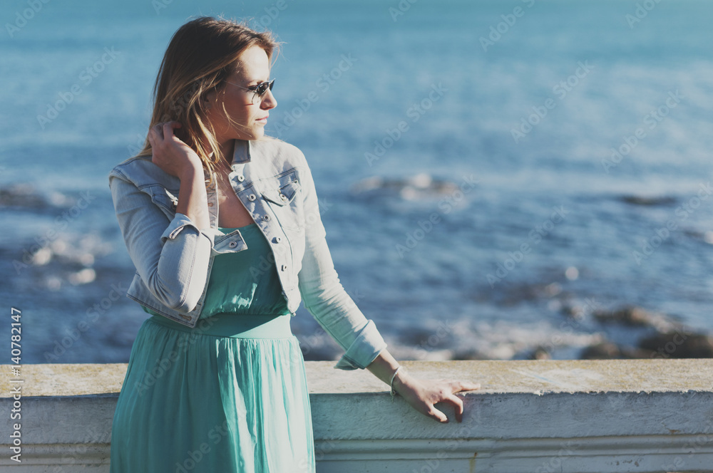 Amazing young woman in green dress near the sea Amazing young woman in green dress near the sea