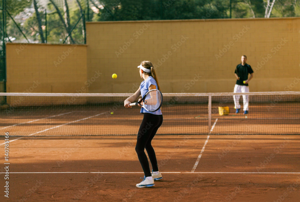 Teenage girl training tennis with her teacher Teenage girl training tennis with her teacher