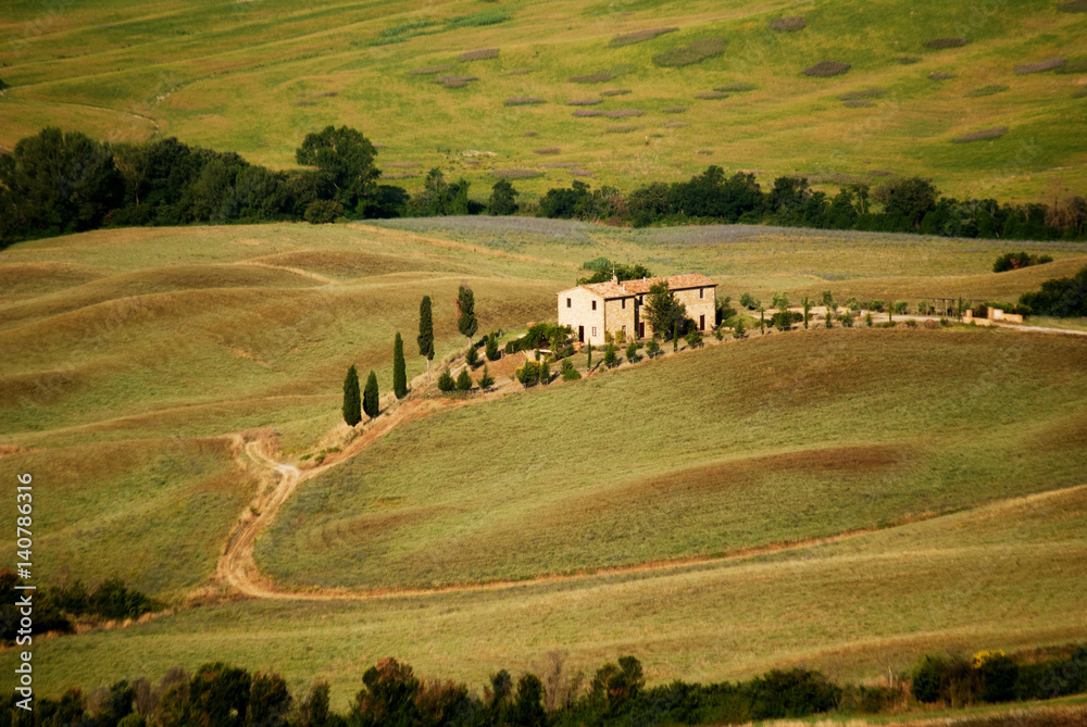 Tuscany farm among green hills and cypresses
