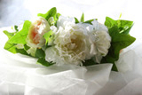 a wreath of white flowers and green leaves on a white background