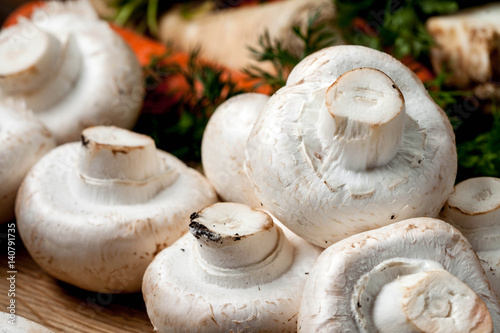 Champignon mushrooms on a wooden cutting board.