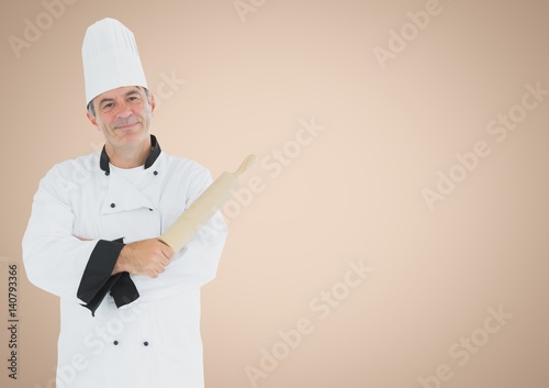 Chef with rolling pin against cream background