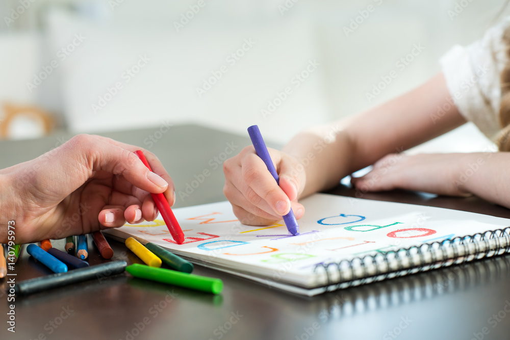 Happy mother and daughter drawing and learning alphabet at home Happy mother and daughter drawing and learning alphabet at home