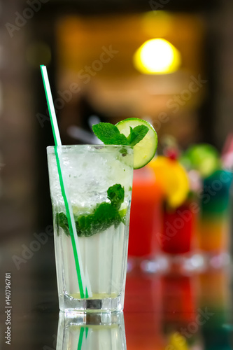 Two fresh mojitos cocktail on wooden background. Mojitos with mint leaves, lime and ice.