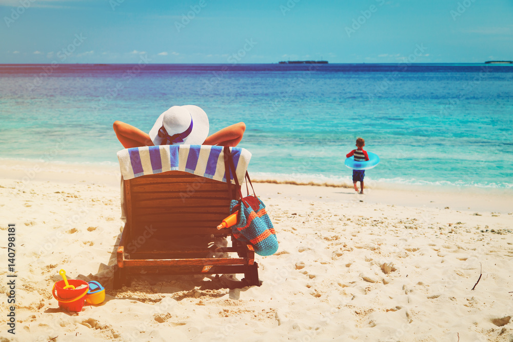 mother relax while child play with water at beach mother relax while child play with water at beach