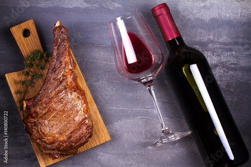 Glass of red wine and rib eye beef steak. Wine and meat still life. View from above, top studio shot