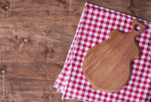 Empty kitchen board for cutting on a brown wooden surface