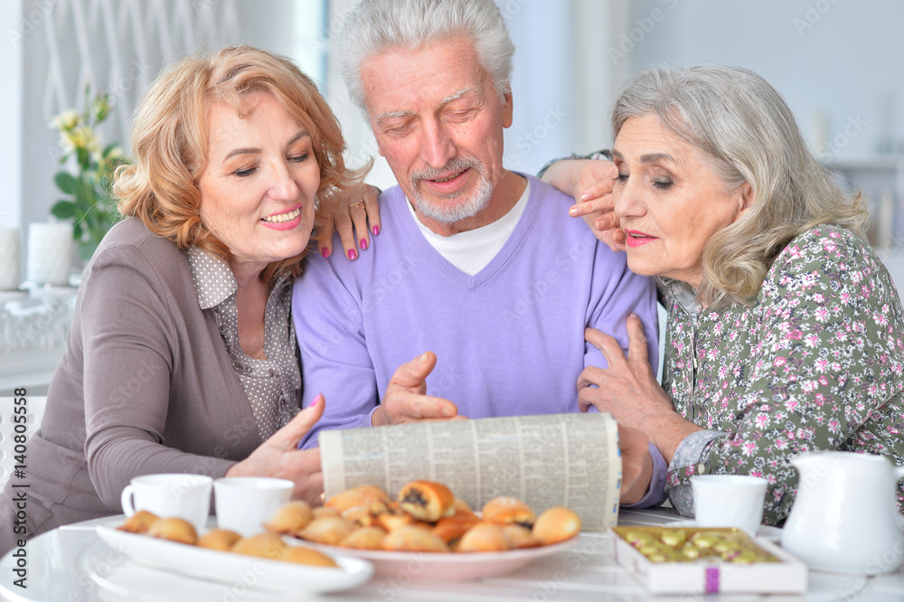 Elderly people having breakfast and reading a newspaper Elderly people having breakfast and reading a newspaper
