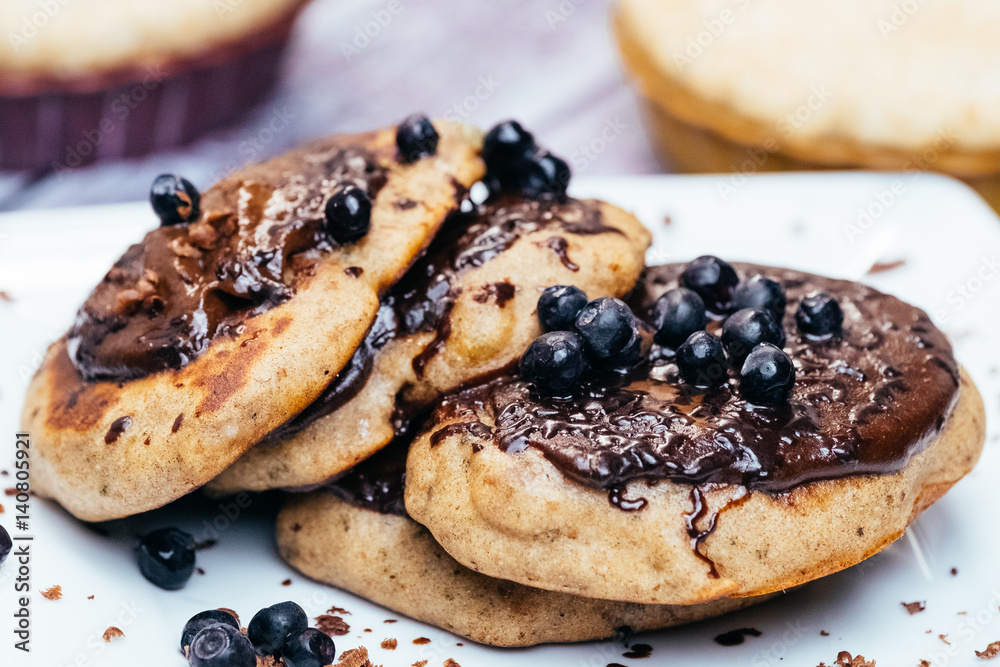 Pancakes stuffed with blueberry jam and sprinkled with blueberries on white plate. Pancakes stuffed with blueberry jam and sprinkled with blueberries on white plate.